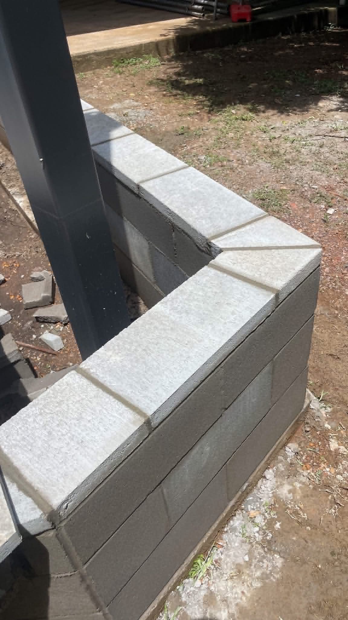 Stepped wall corner detail, charcoal block with cream chamfered cap