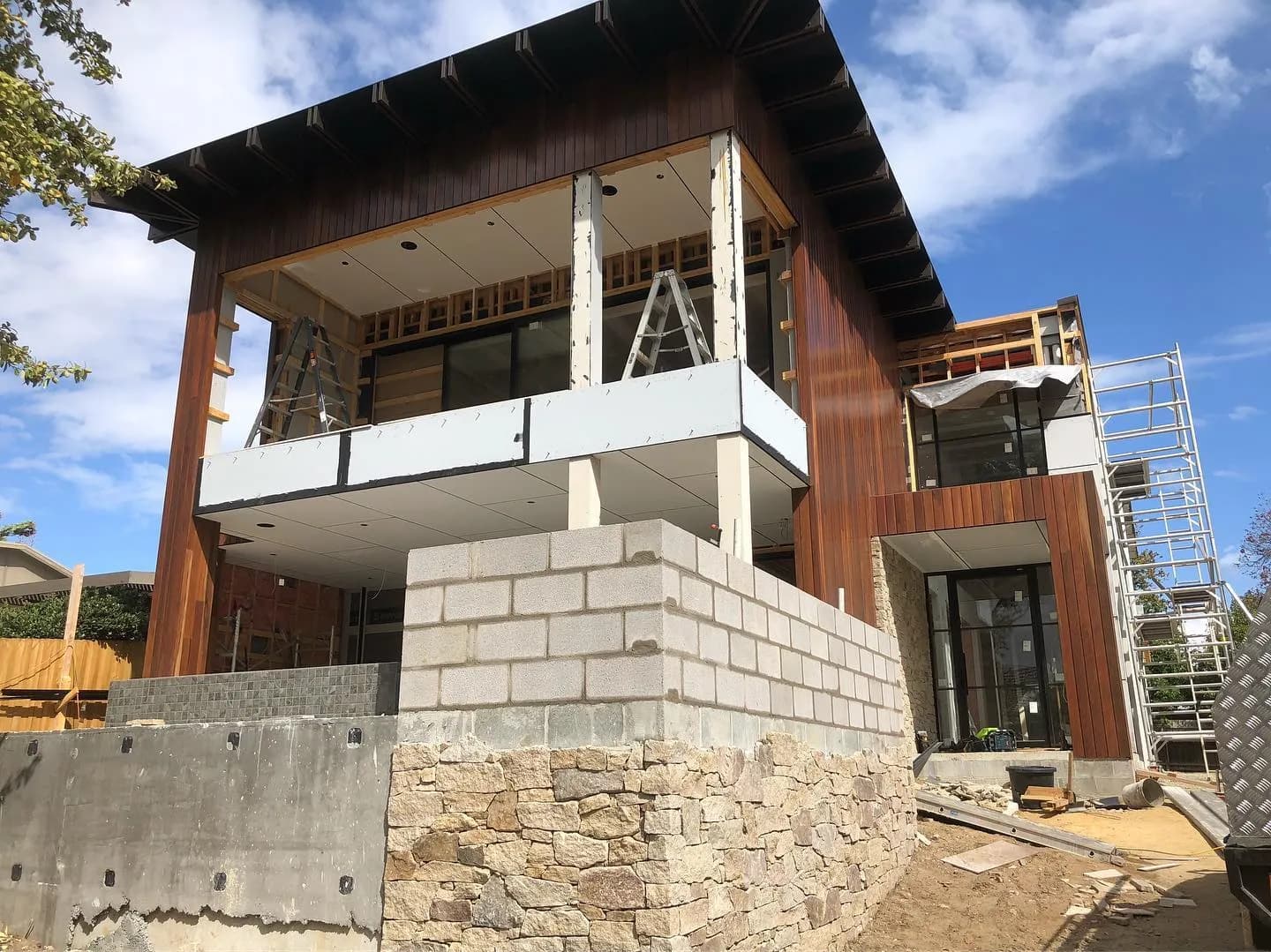 Architectural sandstone base. Random-coursed stone · timber above