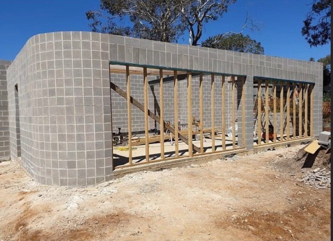 Sweeping curved grey-block wall in daylight