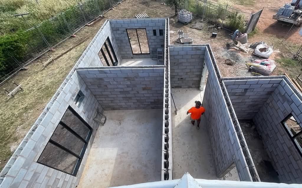 Block home under construction. Aerial · walls up, openings set
